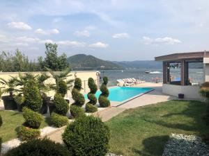 a garden with a swimming pool and a view of the water at Casa Doma Orsova in Orşova