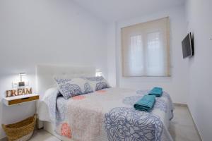 um quarto branco com uma cama e uma janela em ICEBERG LUXURY TARIFA ***** em Tarifa