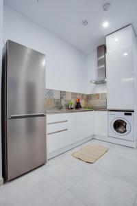 uma cozinha com um frigorífico de aço inoxidável e uma máquina de lavar louça em ICEBERG LUXURY TARIFA ***** em Tarifa