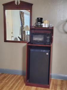 a microwave on top of a wooden stand with a mirror at High Springs Country Inn in High Springs