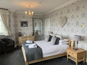 a bedroom with a bed and a chandelier at New Boston Guest Accommodation in Fleetwood