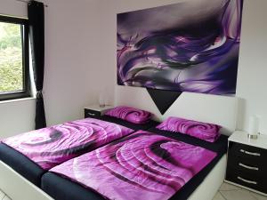 Dormitorio con cama morada y pintura en la pared en Ferienwohnung Tinas Beauty, en Neckarsteinach