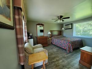 1 dormitorio con 1 cama, 1 silla y 1 ventana en High Springs Country Inn en High Springs