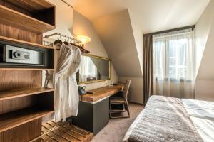 a bedroom with a bed and a dresser at All Seasons Residence Hotel in Sofia