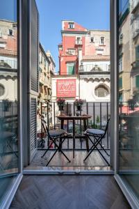 uma varanda com mesa e cadeiras e vista para a cidade em Il Balcone Sui Presepi Apartment em Nápoles