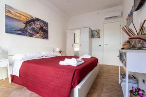 um quarto com uma cama com um cobertor vermelho em Il Balcone Sui Presepi Apartment em Nápoles