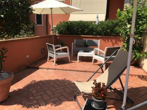 a patio with chairs and an umbrella on a brick patio at Residence Gloria in Montecatini Terme