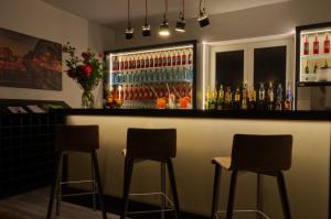 eine Bar mit drei Barhockern in einem Zimmer in der Unterkunft Lizz Hotel Munich in München