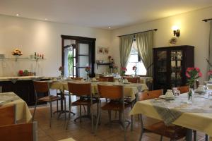 uma sala de jantar com mesas e cadeiras com flores em Pousada Blauberg em Pomerode