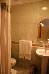 リバデセリャにあるPensión Argüellesのバスルーム(洗面台、トイレ、鏡付)