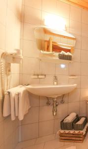 a bathroom with a sink and a mirror and towels at Haus Spieleck in Saalbach-Hinterglemm