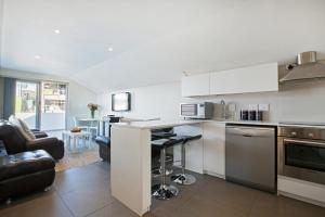 a kitchen with a counter and a living room at 20AB Belladonna Apartments Vredehoek Cape Town in Vredehoek