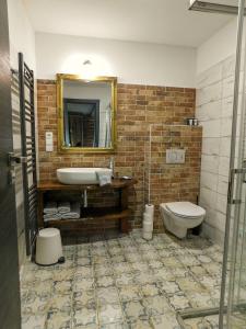 een badkamer met een wastafel, een toilet en een spiegel bij U Paluku in Chrudim
