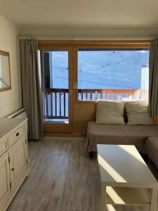 een slaapkamer met een bed en een balkon met uitzicht bij L'olympic in Val Thorens