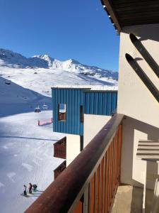 een gebouw waar mensen skiën op een sneeuw bedekte helling bij L'olympic in Val Thorens