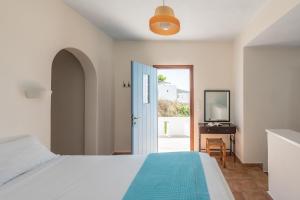 a bedroom with a bed and a door with a mirror at Asterias House in Donoussa