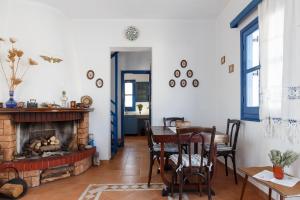 a living room with a fireplace and a table and chairs at House Salvia in Lachania