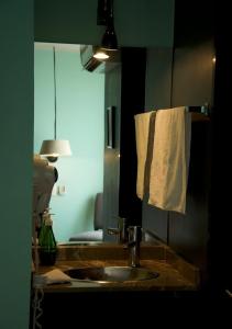 a bathroom with a sink and a mirror and a towel at Lusitania Suites in Orizaba