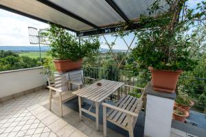 uma mesa e cadeiras numa varanda com plantas em Axia Terme B&B, 4 min dal Centro Storico - PARK privato em Viterbo
