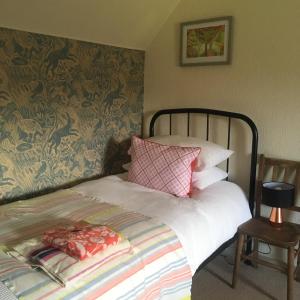 a bedroom with a bed with pink and white pillows at Ardmore House B&B in Lochinver