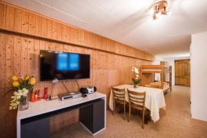 sala de estar con mesa y TV en la pared en Francy, en Brienz