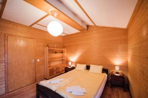ein Schlafzimmer mit einem Bett in einem Holzzimmer in der Unterkunft Bellerive in Brienz