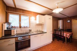 a kitchen with white cabinets and a dining room with a table at Bellerive - Partial lake view in Brienz