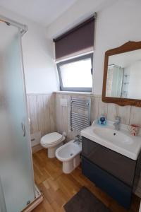 een badkamer met een wastafel, een toilet en een spiegel bij Axia Terme B&B, 4 min dal Centro Storico - PARK privato in Viterbo