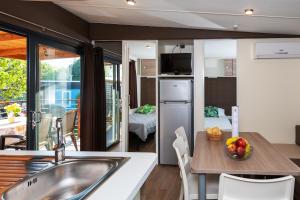 a kitchen with a table with a bowl of fruit on it at Fornella Camping & Wellness family resort in San Felice del Benaco
