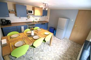 cocina con mesa de madera y sillas verdes en Ferienhaus Winterberg-Zentrum, en Winterberg