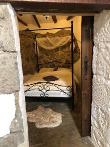 1 dormitorio con 1 cama en una pared de piedra en Casa Rural in Fataga en San Bartolomé