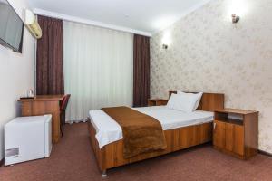 a hotel room with a bed and a desk at Asson Hotel Termez in Termiz