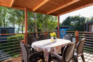a patio with a table and chairs on a deck at Fornella Camping & Wellness family resort in San Felice del Benaco