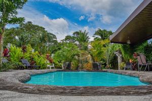 a swimming pool in the middle of a garden at Hotel Sierra Arenal in Fortuna
