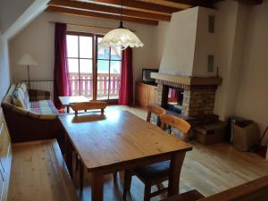 a living room with a wooden table and a fireplace at Antela appartments for up to 5 person on Mariborsko Pohorje in Pohorje