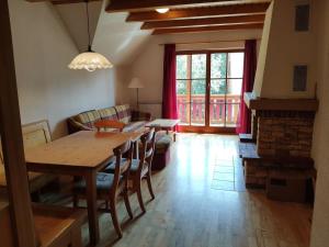 a living room with a wooden table and a couch at Antela appartments for up to 5 person on Mariborsko Pohorje in Pohorje +6 photos