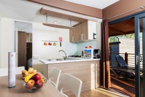 a kitchen and dining room with a bowl of fruit on a table at Fornella Camping & Wellness family resort in San Felice del Benaco