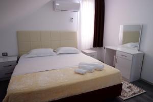 1 dormitorio con 1 cama con 2 toallas en Hotel Kings Apartments, en Kolgecaj