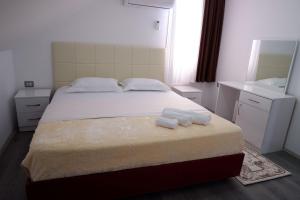 1 dormitorio con 1 cama con 2 toallas en Hotel Kings Apartments, en Kolgecaj