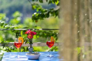 a table with three wine glasses and a vase of flowers at La Casetta in Agerola
