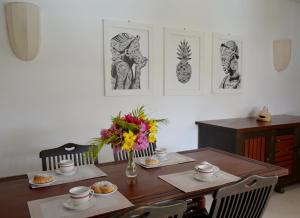 Amani Residence Beverly Suites في ماليندي: طاولة غرفة الطعام مع إناء من الزهور عليها