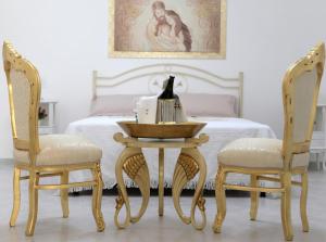 1 Schlafzimmer mit einem Bett mit einem Tisch und 2 Stühlen in der Unterkunft De Mola Holiday House in Pezze di Greco