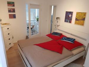 Un dormitorio con una cama con almohadas rojas. en Christels Gästewohnung en Bünde