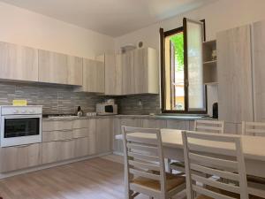 a kitchen with wooden cabinets and a table and chairs at Alla Tomba di Giulietta in Verona