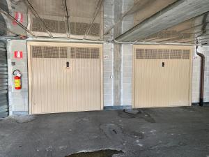 zwei braune Türen in einer Garage mit einem Feuerlöscher in der Unterkunft Casa Gaia in Lerici