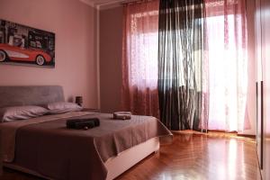 a bedroom with a bed and a large window at Giolitti Luxury Apartment in Cuneo
