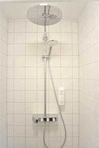 una ducha con cabezal de ducha en un baño en Nuuk City Hostel, en Nuuk