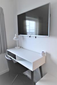 Un escritorio blanco con un espejo grande en la pared. en Nuuk City Hostel, en Nuuk