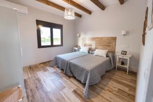 a bedroom with a bed and a wooden floor at Casa Rural Las Caleras in Daimiel
