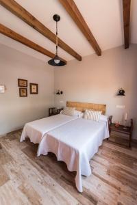 ein Schlafzimmer mit einem großen Bett mit weißer Bettwäsche in der Unterkunft Casa Rural Las Caleras in Daimiel